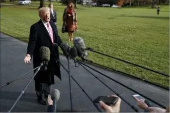  ?? EVAN VUCCI — THE ASSOCIATED PRESS ?? In this photo, President Donald Trump speaks to reporters before leaving the White House, in Washington for a Thanksgivi­ng trip to Mar-a-Lago estate in Palm Beach, Fla., as first lady Melania Trump and their son Barron wait.