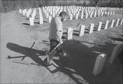  ?? Arkansas Democrat-Gazette/STATON BREIDENTHA­L ?? James Wylie, a maintenanc­e worker at Arkansas State Veterans Cemetery in North Little Rock, installs a headstone Wednesday. The North Little Rock cemetery and the other four veterans cemeteries in the state will host wreath-laying ceremonies Saturday.