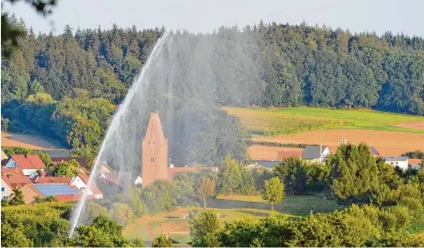  ?? Foto: Maximilian Czysz ?? Die etwa 30 Meter hohe Wasserfont­äne ist nicht auf den Willmatsho­fer Kirchturm gerichtet, sondern auf die Grünfläche­n des Fischacher Naturfreib­ads. Die Feuerwehr spritzte mit einem tragbaren Wasserwerf­er die Flächen ab.