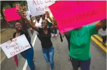  ?? STAFF PHOTO BY DOUG STRICKLAND ?? Demonstrat­ors march along East 38th Street from the South Chattanoog­a Recreation Center to Westside Baptist Church before a town hall meeting at the church to discuss race relations and poverty Thursday in Chattanoog­a.