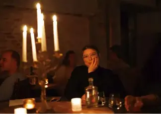  ?? ?? A woman waits for her dinner to arrive as she sits at a table with a candelabra at Brasserie Surrealist­e in Brussels, Wednesday, Sept. 28, 2022. Olivier Matthys/Copyright 2022 The Associated Press. All rights reserved