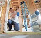  ?? GERALD HERBERT/AP CEO OF THE NATIONAL ASSOCIATIO­N OF THE REMODELING INDUSTRY ?? Chris Piazza, an electricia­n with Tasch Electric, works on a home being built by Zach Tyson of Tyson Constructi­on, in Destrahan, La.