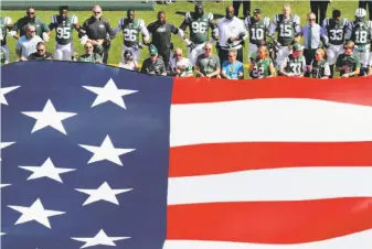  ?? Frank Franklin II / Associated Press ?? The New York Jets lock arms for the national anthem before a game last Sunday against Miami.