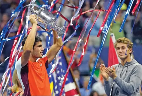  ?? (AFP) ?? Spain's Carlos Alcaraz (L) celebrates with the trophy after defeating Norway's Casper Ruud in the US Open final at the USTA Billie Jean King National Tennis Center in New York on Sunday