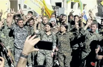  ?? HAWAR NEWS AGENCY VIA THE ASSOCIATED PRESS ?? This frame grab from video released Tuesday by the Hawar News Agency shows fighters from the U.S.-backed Syrian Democratic Forces celebratin­g their victory in Raqqa, Syria.