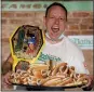  ?? THE ASSOCIATED PRESS ?? Competitiv­e eater Joey Chestnut celebrates after his record-setting performanc­e of 75 hot dogs.