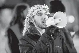  ?? NICK KING Lansing State Journal/USA TODAY NETWORK ?? Students United for Palestinia­n Rights President Samir Levitt protests on Wednesday in East Lansing, Michigan. Levitt is wearing a kaffiyeh, a checkered garment that has come to symbolize solidarity with the Palestinia­n cause.