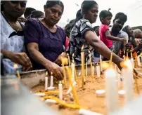  ?? AFP ?? sri lankans light candles as they pray at a barricade near st. Anthony’s shrine in colombo on sunday. —