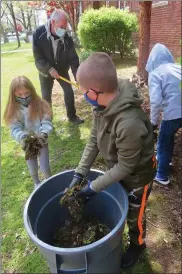  ?? DAN SOKIL — MEDIANEWS GROUP ?? York Avenue Elementary School fourth-graders hold and carry piles of moss and plant debris as part of a project to beautify the outside of their school for Earth Day.