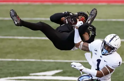  ?? Associated Press ?? Penn State safety Jaquan Brisker upends Rutgers wide receiver Bo Melton in the second half of the Nittany Lions’ 23-7 win last Saturday. The senior, who had his best game of the season against the Scarlet Knights, is a candidate to return next season.