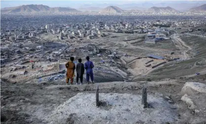  ??  ?? Afghan children by a grave of a victim of the recent attack on Sayyid al-Shuhada school in west Kabul. Photograph: Hedayatull­ah Amid/ EPA