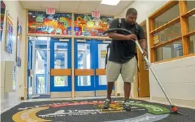  ?? Steve Mellon/Post-Gazette ?? Andre Turner of A&A Turner Enterprise vacuums the entry at Penn Hills Charter School in Penn Hills on June 14. Mr. Turner and his wife, Ashley, founded the company in 2015.