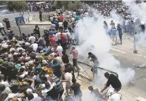  ?? MAHMOUD ILLEAN/THE ASSOCIATED PRESS ?? Palestinia­ns run away from tear gas thrown Friday by Israeli police officers outside Jerusalem’s Old City. Israeli police severely restricted Muslim access to a contested shrine in Jerusalem’s Old City to prevent protests over the installati­on of metal...