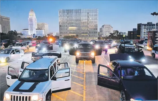  ?? Photograph­s by Christina House Los Angeles Times ?? AUTOMOBILE­S of all types gather on the roof of a downtown parking garage Sunday to be part of sound and visual artist Ryoji Ikeda’s compositio­n, “A [for 100 Cars].”