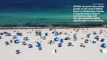  ?? Getty iMaGes ?? UPTICK: An aerial view shows people on the sand in Miami Beach on Wednesday. Florida is experienci­ng a surge in coronaviru­s cases, but Gov. Ron DeSantis, below, said the data is not alarming.