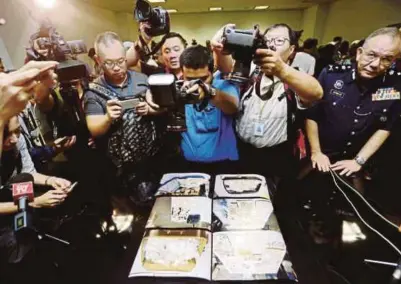  ?? [FOTO ZULFADHLI ZULKIFLI/BH] ?? Pengamal media mengambil gambar barang rampasan berkaitan kes 1MDB pada sidang media di Ibu Pejabat JSJK, Kuala Lumpur, semalam.