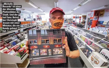  ??  ?? „Michelle Records“ist einer der ältesten Plattenläd­en der Stadt. Und der hat Fans: Betreiber Christoph Jessen mit einer Miniatur, die ein Kunde gebaut hat.