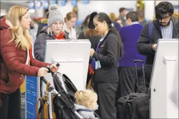  ?? Nam Y. Huh Associated Press ?? TRAVELERS CHECK in at Chicago’s O’Hare airport. As much as a foot of snow was expected in the city.