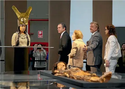  ?? PHOTO: REUTERS ?? Peru’s Culture Minister Salvador del Solar, centre, and visitors look at the replica of the Lady of Cao and her mummy at the culture ministry in the capital, Lima. The priestess is believed to have ruled over a complex desert society about 1700 years...