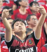  ?? AFP ?? A fan of China’s Guangzhou Evergrande gives the finger towards fans of Hong Kong’s Eastern.