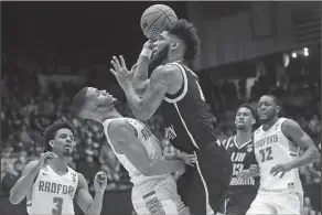  ?? Associated Press ?? Tough shot: LIU Brooklyn's Joel Hernandez, center right, shoots against Radford's Travis Fields Jr. during the first half of a First Four game of the NCAA Tournament Tuesday in Dayton, Ohio.