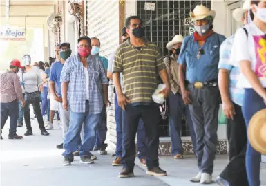  ?? Photos by Mario Tama / Getty Images 2020 ?? Workers line up for jobless claims in Calexico (Imperial County), near the U.S.Mexico border, in July.