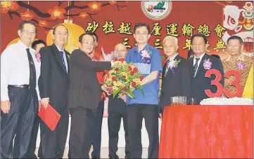  ??  ?? Jong (third left) presents a hamper to Tan, while others look on. — Photo by Chin Tze Pin