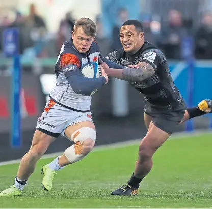  ?? Picture: Getty Images. ?? Edinburgh’s Darcy Graham bursts away from a Sonatane Takulua tackle.