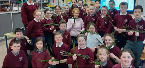  ??  ?? Una Casey with 5th Class pupils from Scoil Phádraig Naofa, Kilcurry making St Brigid’s crosses.