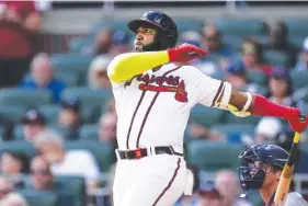  ?? AP PHOTO/JOHN BAZEMORE ?? Atlanta Braves designated hitter Marcell Ozuna follows through on his three-run homer in the third inning of Sunday’s home game against the Washington Nationals. Ozuna also hit a solo homer in the ninth inning as the Braves tied the 2019 Minnesota Twins for MLB’s singleseas­on home run record with 307, but Washington won 10-9 in the regular-season finale.