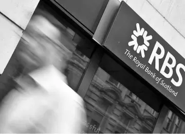  ?? — Reuters photo ?? A man walks past a branch of The Royal Bank of Scotland (RBS) in central London in this Aug 27, 2014 file photo.