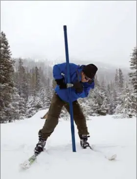  ?? RICH PEDRONCELL­I — THE ASSOCIATED PRESS ?? John King of the Department of Water Resources, thrust the snow survey tube into the snowpack while conducting the third manual snow survey of the season at the Phillips Station near Echo Summit Thursday. The survey found the snowpack at 113 inches deep with a snow water equivalent of 43.5 inches at this location at this time of year.