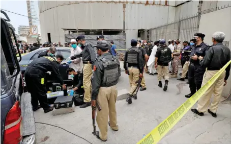  ?? Reuters ?? Members of the Crime Scene Unit of Karachi Police prepare to survey the site of an attack at the Pakistan Stock Exchange entrance in Karachi on Monday.