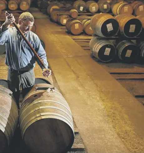  ??  ?? 0 A worker at Bruichladd­ich distillery in Islay takes a whisky sample from a cask