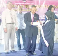  ??  ?? AWANG Damit (tengah) menyampaik­an sijil kepada salah seorang pelajar pada majlis itu.