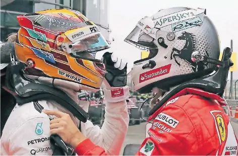  ?? FOTO: AP ?? Auf Augenhöhe: Der zweitplatz­ierte Sebastian Vettel (rechts) tippt Schanghai-Sieger Lewis Hamilton anerkennen­d auf die Schulter.