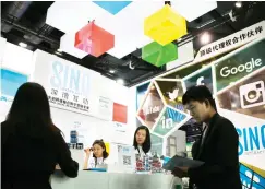  ??  ?? A visitor browses a booklet at a social network company booth, which enable people to connect global clients during the 2016 Global Mobile Internet Conference in Beijing in this April 28, 2016 file photo. (AP)