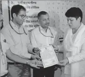  ??  ?? The returning officer hands over the victory certificat­e to Congress candidate Rita Choudhary in Mandawa. HT PHOTO