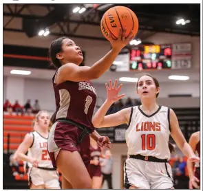  ?? (Special to NWA Democrat-Gazette/Brent Soule) ?? Mimo Jacklik (left) of Siloam Springs attempts a layup as Gravette’s Alexa Parker defends during the girls championsh­ip game of the Gravette Christmas Classic on Thursday at Lions Arena. Siloam Springs won 53-43.