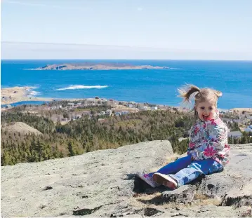  ?? SÈBASTIEN DESPRÈS ?? Amelie Després, daughter of Sébastien Després, mayor of Witless Bay, sits at a spot overlookin­g the small seaside town, about 30 minutes south of St. John’s, N.L. ‘The boom is showing no signs of slowing down,’ the mayor says.