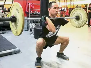  ??  ?? Gaining strength: Loh performing weighted squats at his gym.