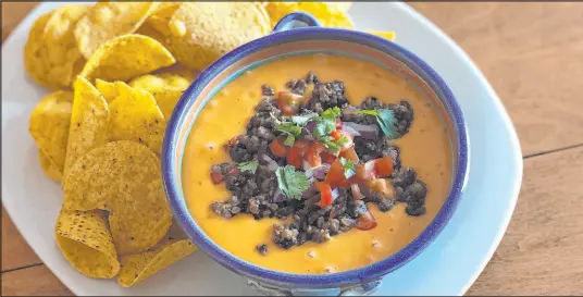  ?? Nicole Hvidsten Star Tribune ?? Recipes where meat plays a supporting role, such as this nacho dip with plant-based crumbles, can be a good starting point.