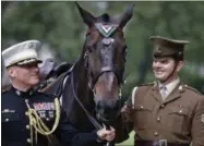  ?? FRANK AUGSTEIN — THE ASSOCIATED PRESS ?? Horse Haldalgo, representi­ng life-saving US Marine horse Sergeant Reckless who served with the US Marine Corps during the Korean War, is awarded with the PDSA Dickin Medal beside Sergeant Mark Gostling, right, and Lieutenant Colonel Michael Skaggs in...