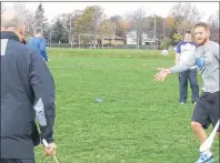  ?? SUBMITTED PHOTO ?? Bluefield High School phys-ed teacher Ryan Laughlin, right, throws a hand pass to Stonepark phys-ed teacher Chris Harkness, left, as P.E.I. Gaelic Athletic Associatio­n president Shane O’Neill, background, looks on. The PEIGAA held a recent hurling...