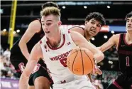  ?? Morry Gash / Associated Press ?? Wisconsin’s Tyler Wahl drives past Stanford’s Brandon Angel during the first half in Milwaukee.