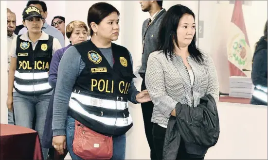  ?? HO/AP ?? Keiko Fujimori, escoltada por la policía y con esposas (ocultas bajo la chaqueta), en el momento de llegar a la oficina del fiscal