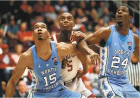  ?? Scott Strazzante / The Chronicle ?? North Carolina's Garrison Brooks (15) and Kenny Williams (24) box out Stanford's Kodye Pugh during the first half.