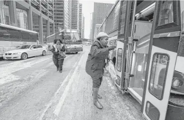  ?? Steve Gonzales / Houston Chronicle ?? After a pair of Metro buses became disabled, commuters fought the elements to board another bus downtown at McKinney and Louisiana on Tuesday.