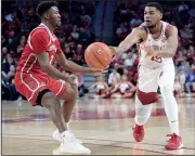  ?? NWA Democrat-Gazette/ANDY SHUPE ?? Arkansas’ Mason Jones (right) passes around South Dakota’s Triston Simpson on Friday at Bud Walton Arena in Fayettevil­le.