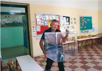  ?? ?? A municipal worker carries a ballot box in a school room which is going to be used as a polling station in central Athens, on May 19, two days ahead of the general elections scheduled for May 21, 2023.